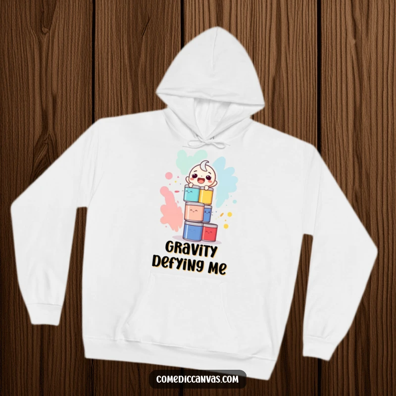 Funny hoodie print of a laughing character precariously balancing a high stack of colorful paint cans, ready to spill.